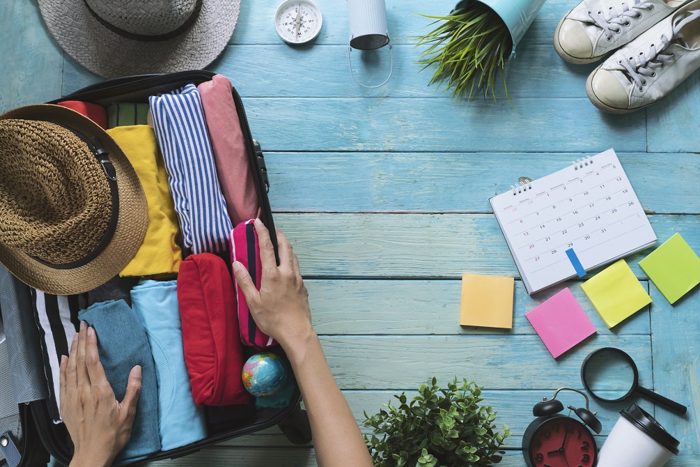 Woman hands packing a luggage