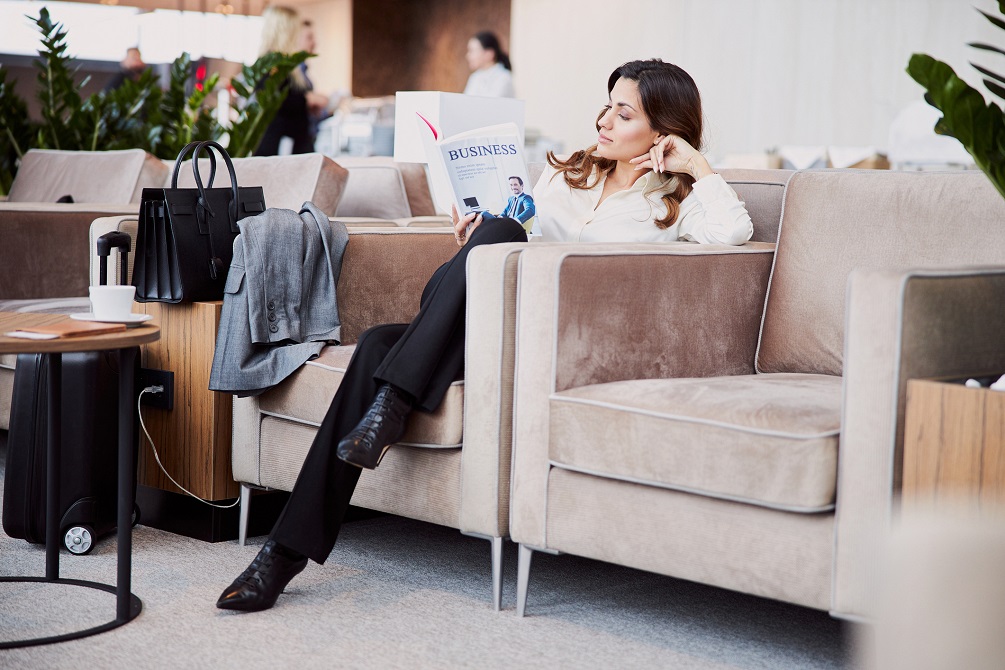 woman reading book in departure lounge airport